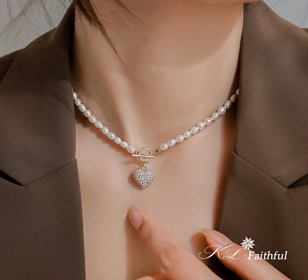 Model wearing gold pearl heart necklace styled with brown blazer