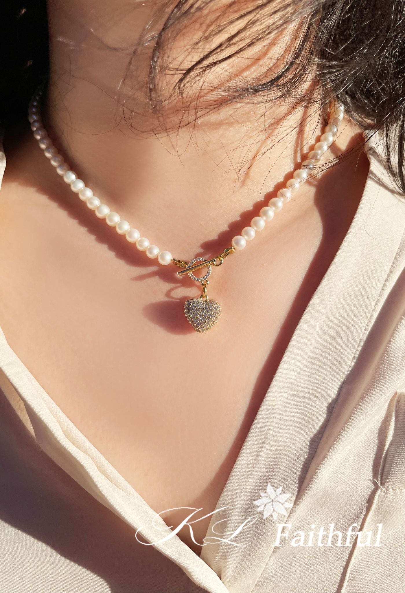 Pearl necklace with heart pendant glowing under natural sunlight